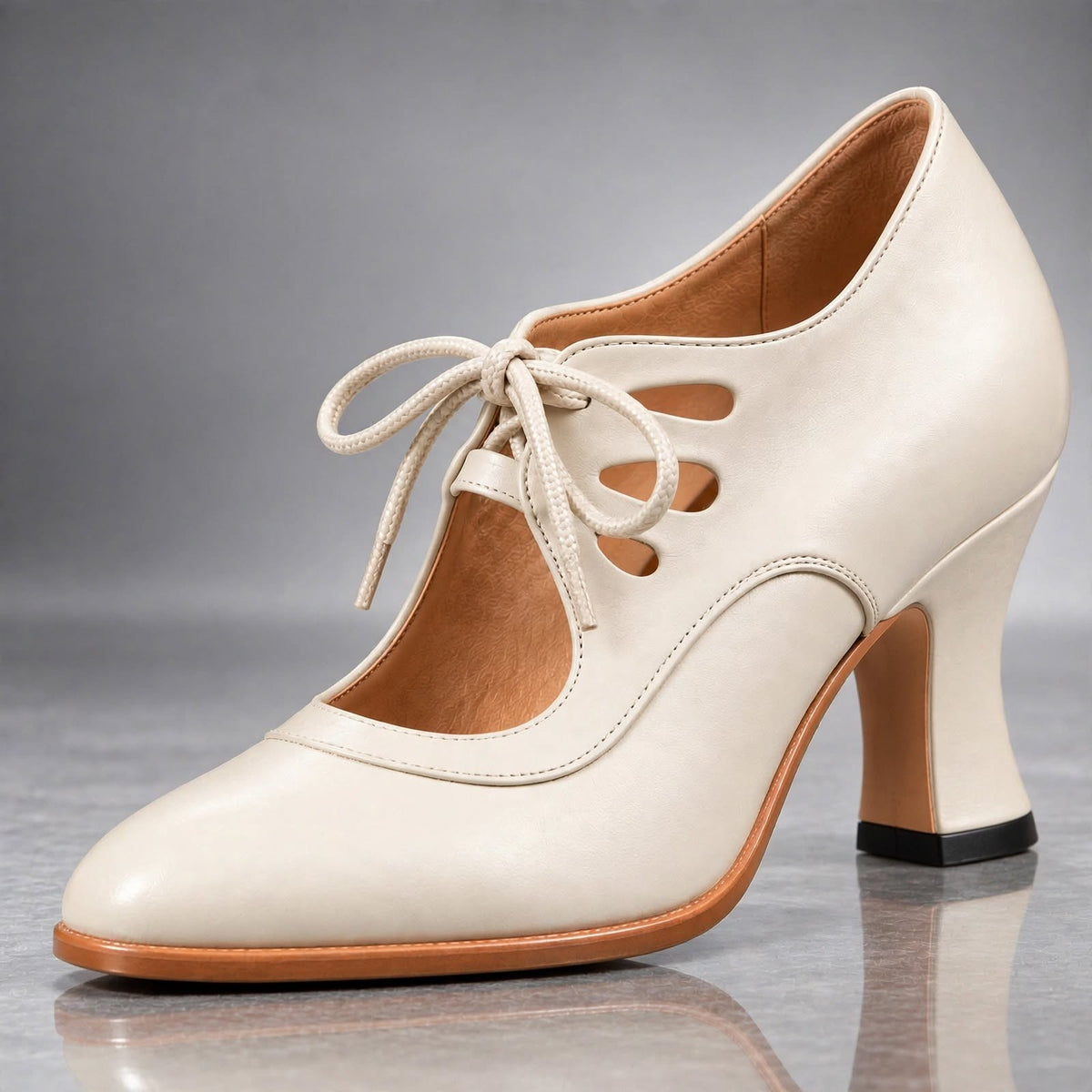 Tacones Audrey en crema: pala de piel, cordones delanteros, calado retro y tacón curvo