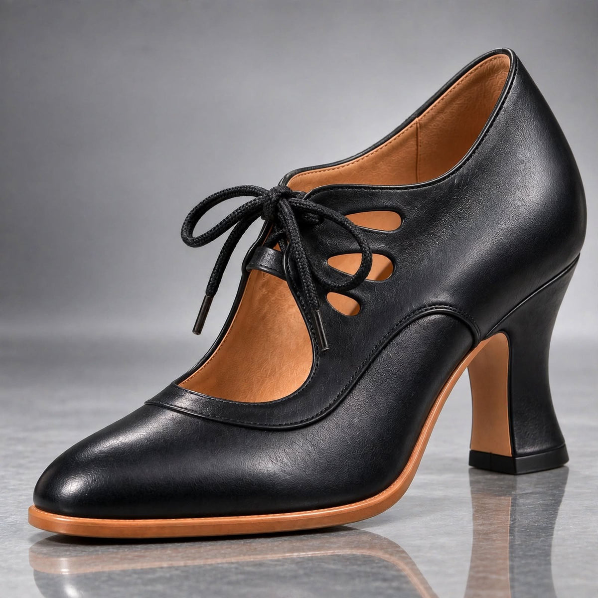 Tacones Audrey en negro: pala de piel, cordones delanteros, calado retro y tacón curvo