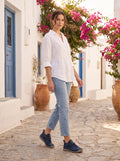 Zapatillas Oriana azul marino con vaquero y camisa de lino en una calle encalada